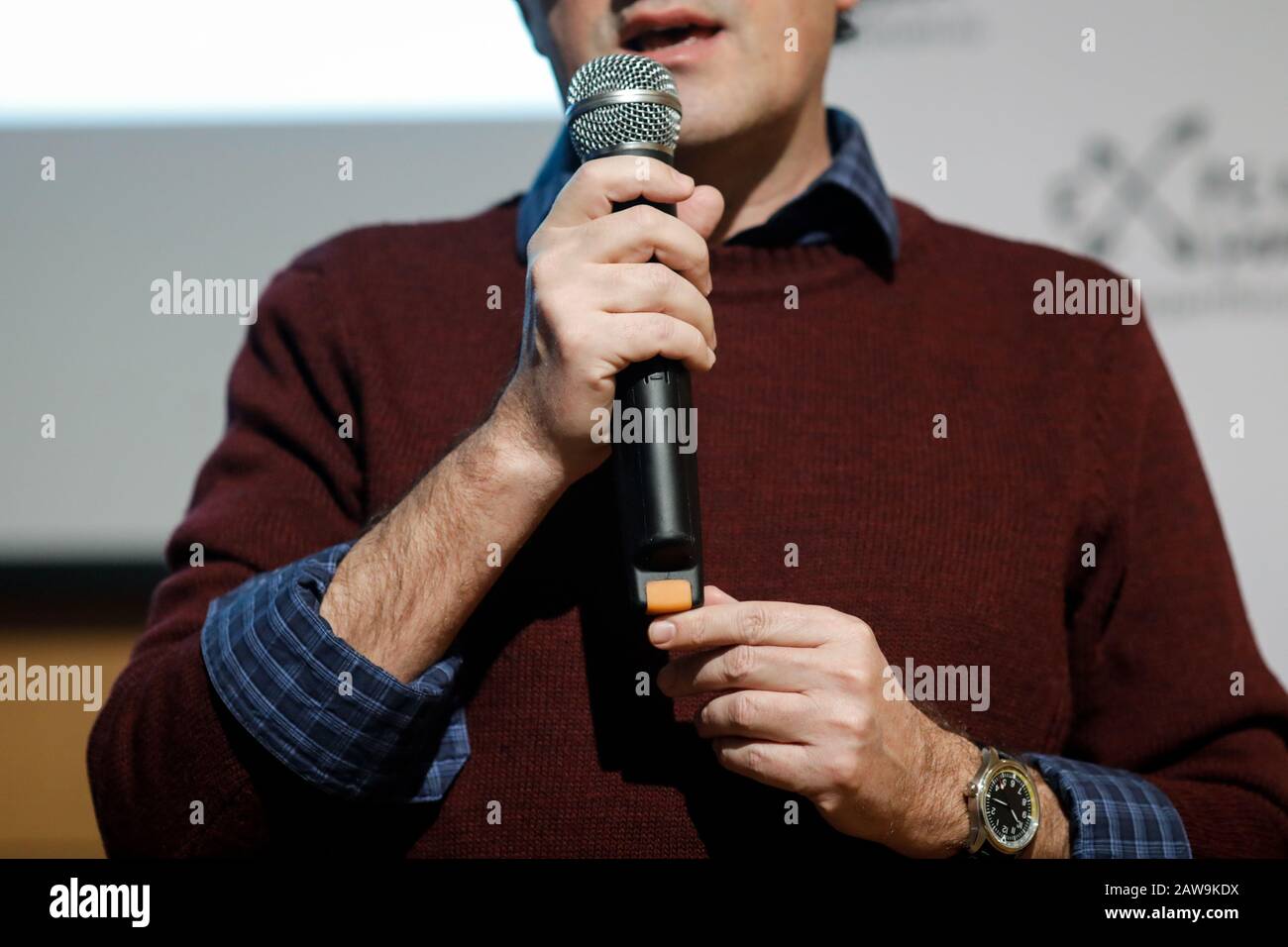 Shallow depth of field (selective focus) image with the hands of a man holding a microphone and delivering a speech. Stockfoto