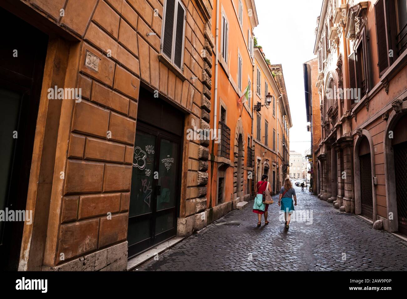 Eine Frau, die mit einer anderen Frau im Zentrum Roms auf einem Rundgang durch die Stätten spazieren ging. Rom, Italien. Stockfoto