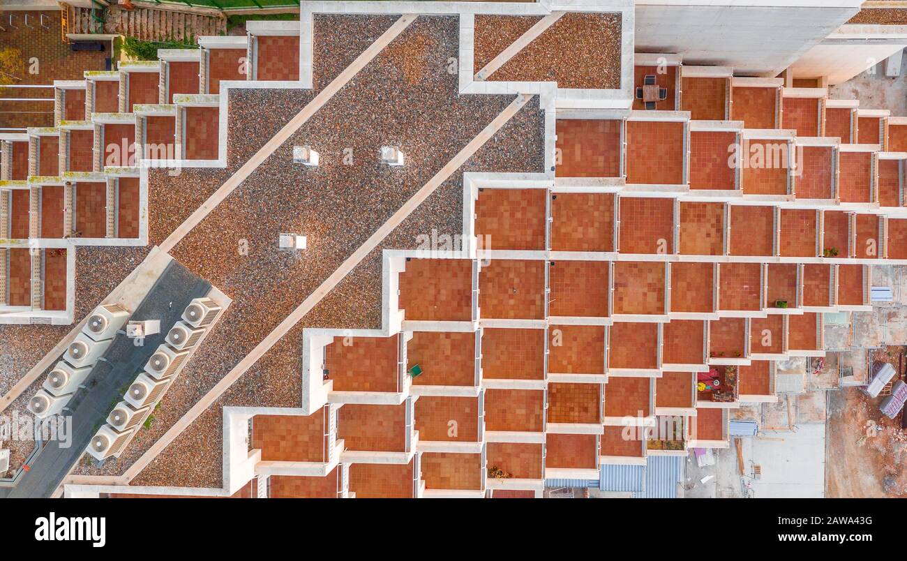 Blick auf ein mehrstöckiges Gebäude mit orangefarbenen, quadratischen Terrassen in Tarragona Spanien Stockfoto