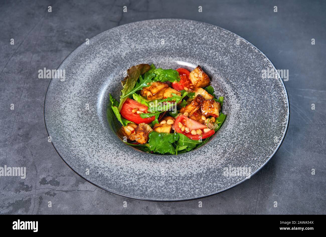 Platte mit frischem Salat auf grauem Tisch Stockfoto