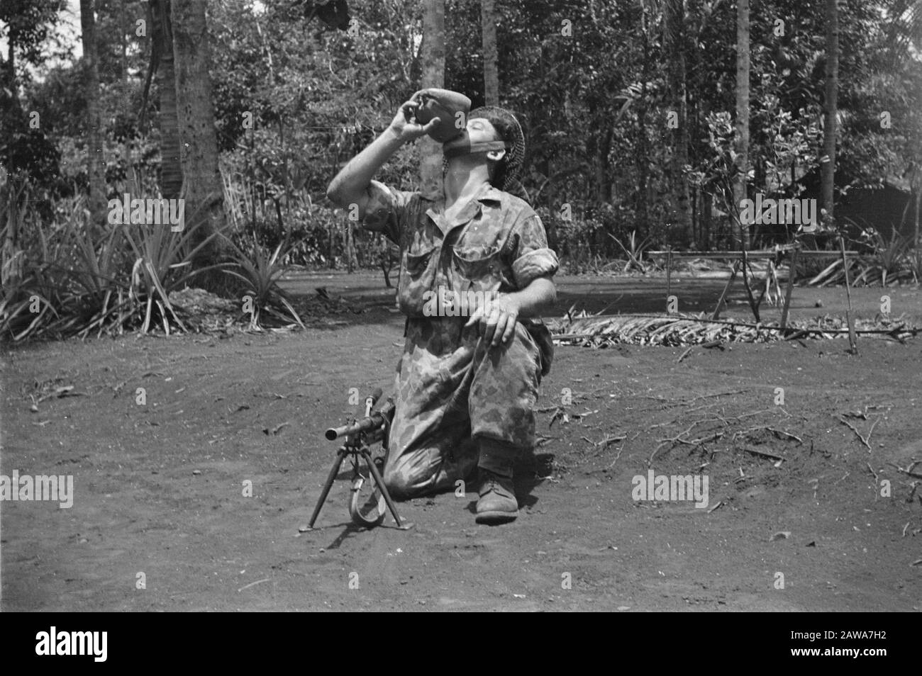 Bandung Machine Gunner stillt seinen Durst mit Coconut Date: 1946 Ort: Bandung, Indonesien, Niederländische Ostindien Stockfoto