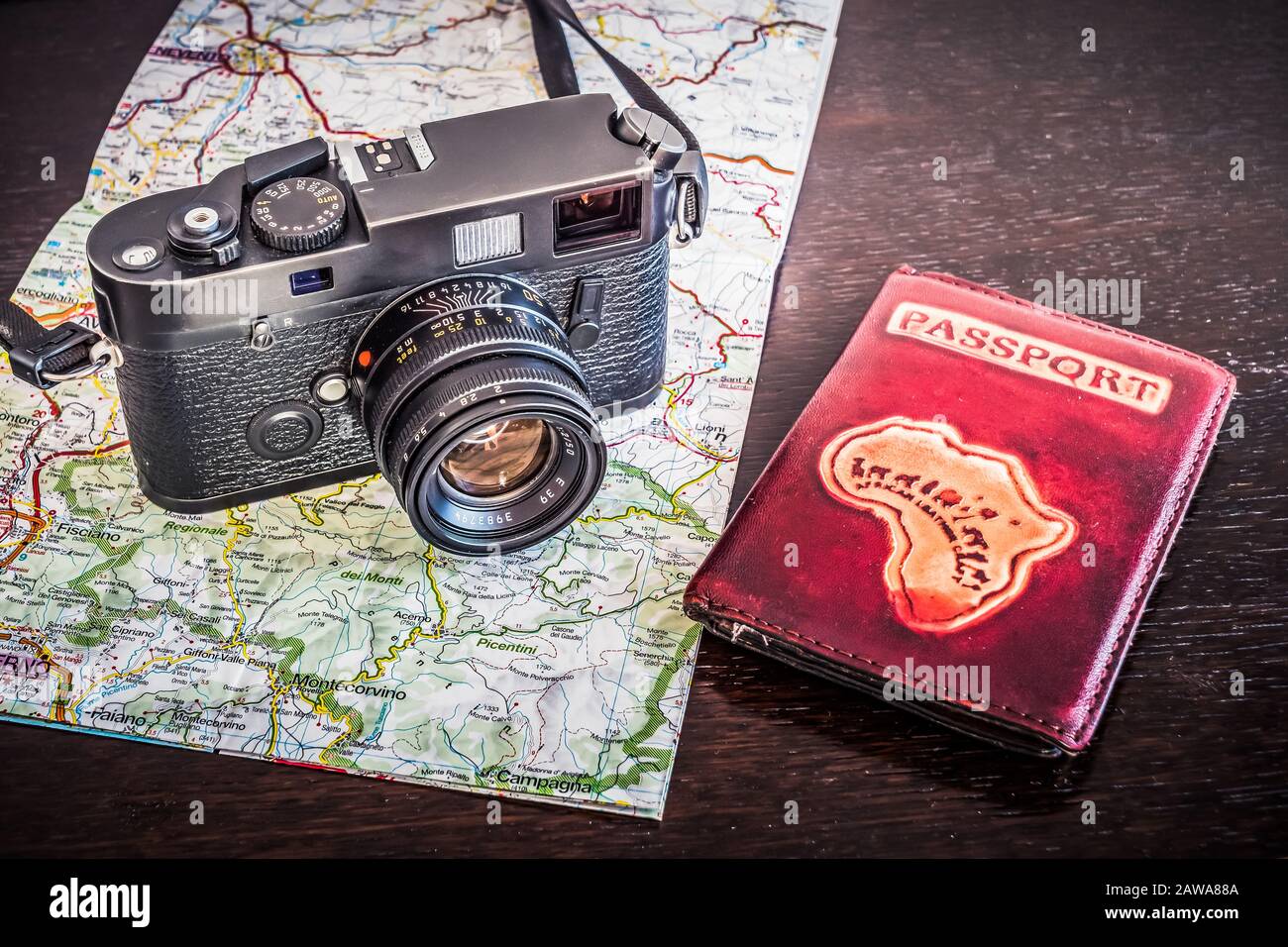 Reisefotografie-Konzept - Schwarz, Retro, Vintage-Fotokamera, Passport und Karte auf dunklem Holzhintergrund - Vintage-Look Stockfoto