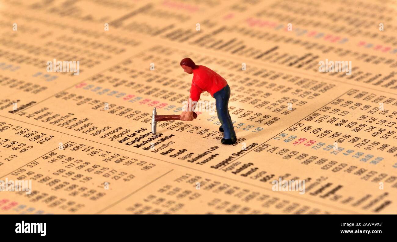 Modell des Mannes in rotem Hemd mit wählenden Taxen, auf Aktien und Aktien Seite der Finanzzeitung. Stockfoto