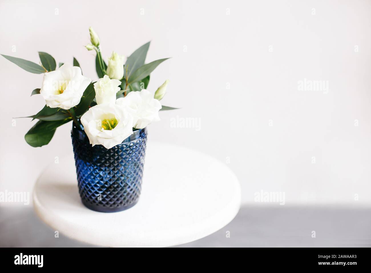 Weiße Blumen in klassischem blauem Glas. Lisianthus. Kunden. Stockfoto