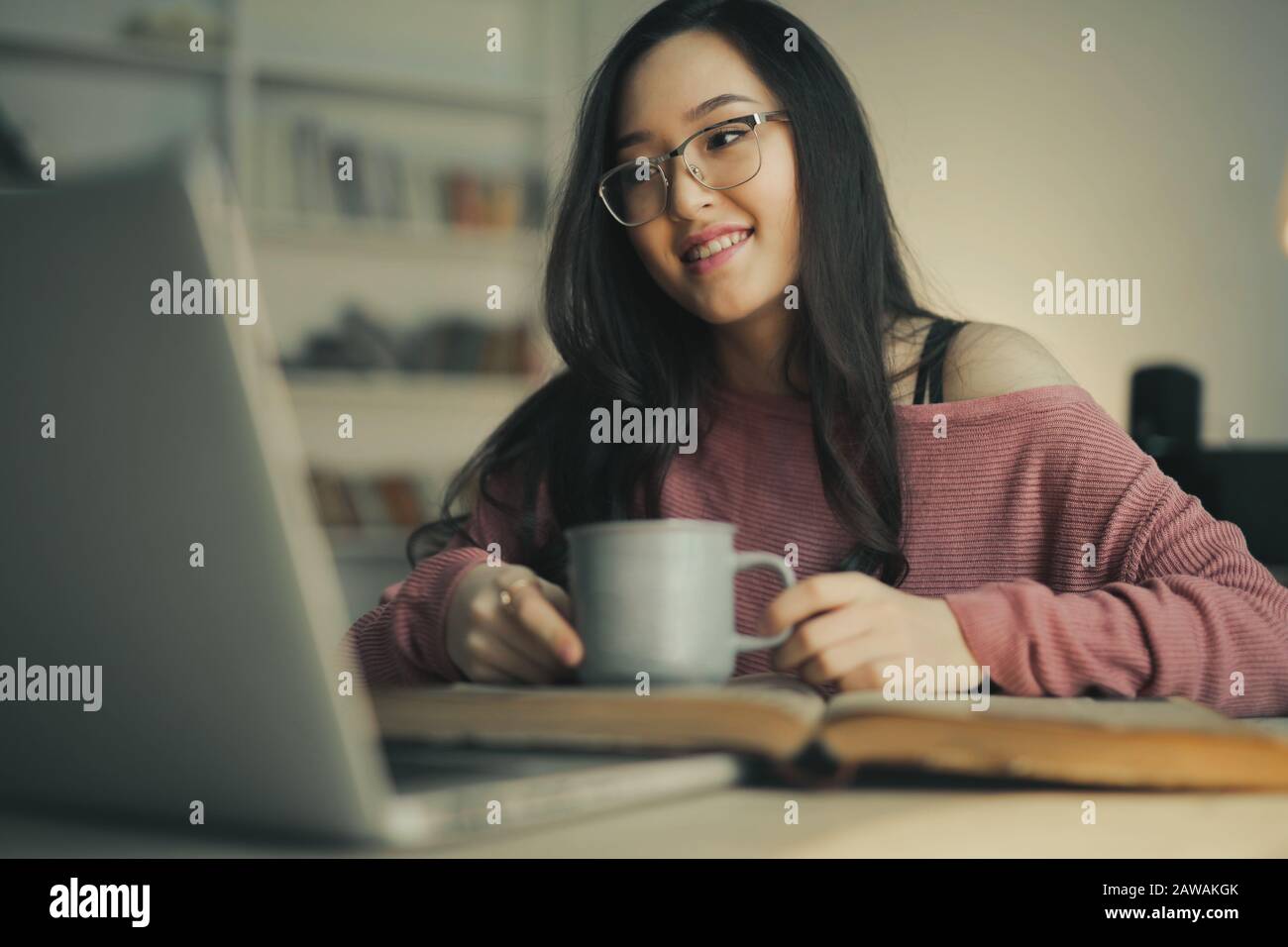 asiatische Frau lächelnd mit einem Laptop Stockfoto