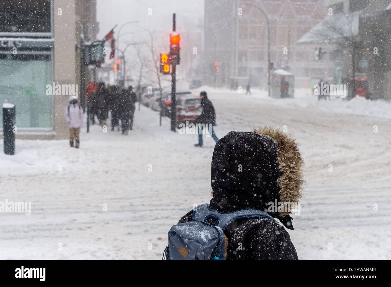 Montreal, CA - 7. Februar 2020: Fußgänger, die während des Schneesturms in der Innenstadt von Montreal spazieren. Stockfoto