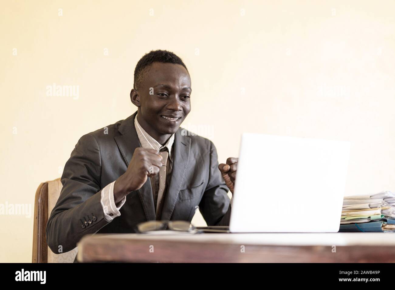 Schwarzer glücklicher Mann, der die Arbeit eines im Büro tätigen Mitarbeiters konzentriert Stockfoto