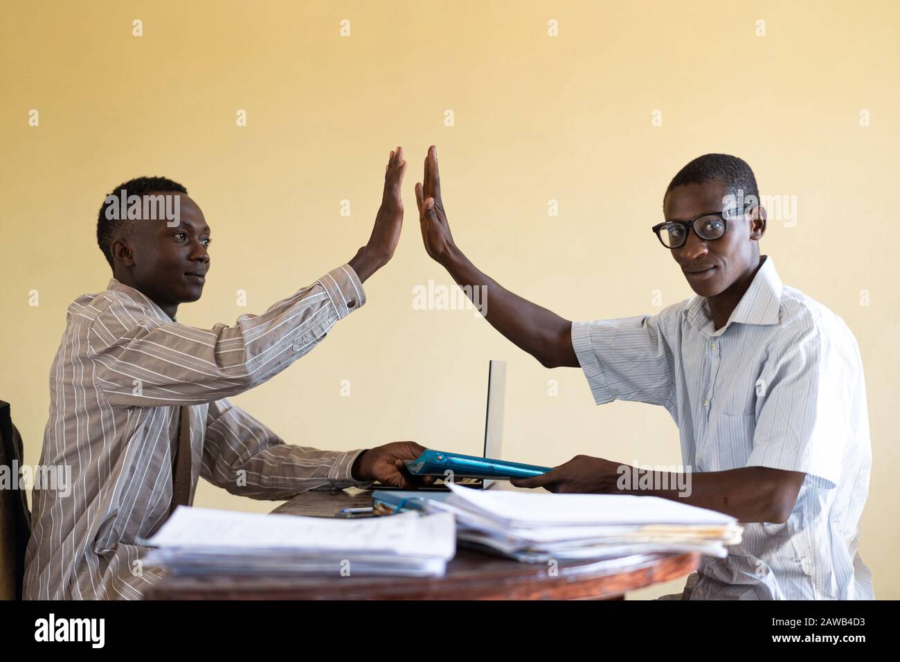 Nahaufnahme von zwei schwarzen Männern in Afrika, Die Fünf Im Büro hoch sind, nachdem sie Geld verdient haben Stockfoto