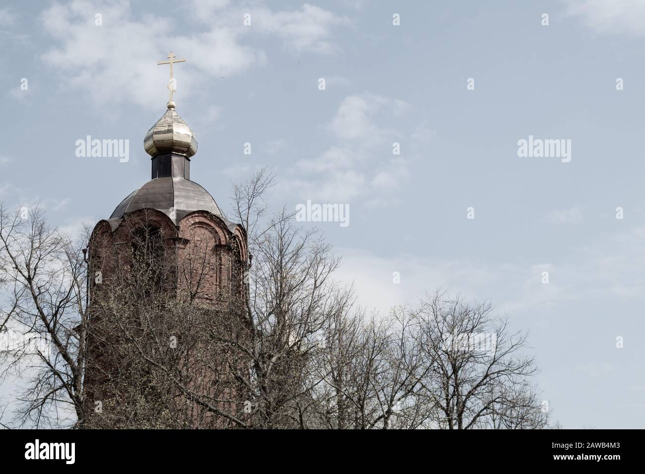 Schöner alter Kirchturm mit Kreuz unter Bäumen, Kapelle im Wald Stockfoto