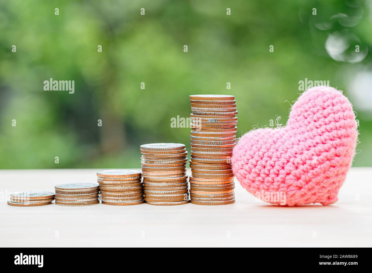 Wunderschönes Herz mit Geldmünzenstapel für die Liebe zum Sparen oder halten von Geschäftsgewinn oder medizinischem Schutzkonzept. Stockfoto
