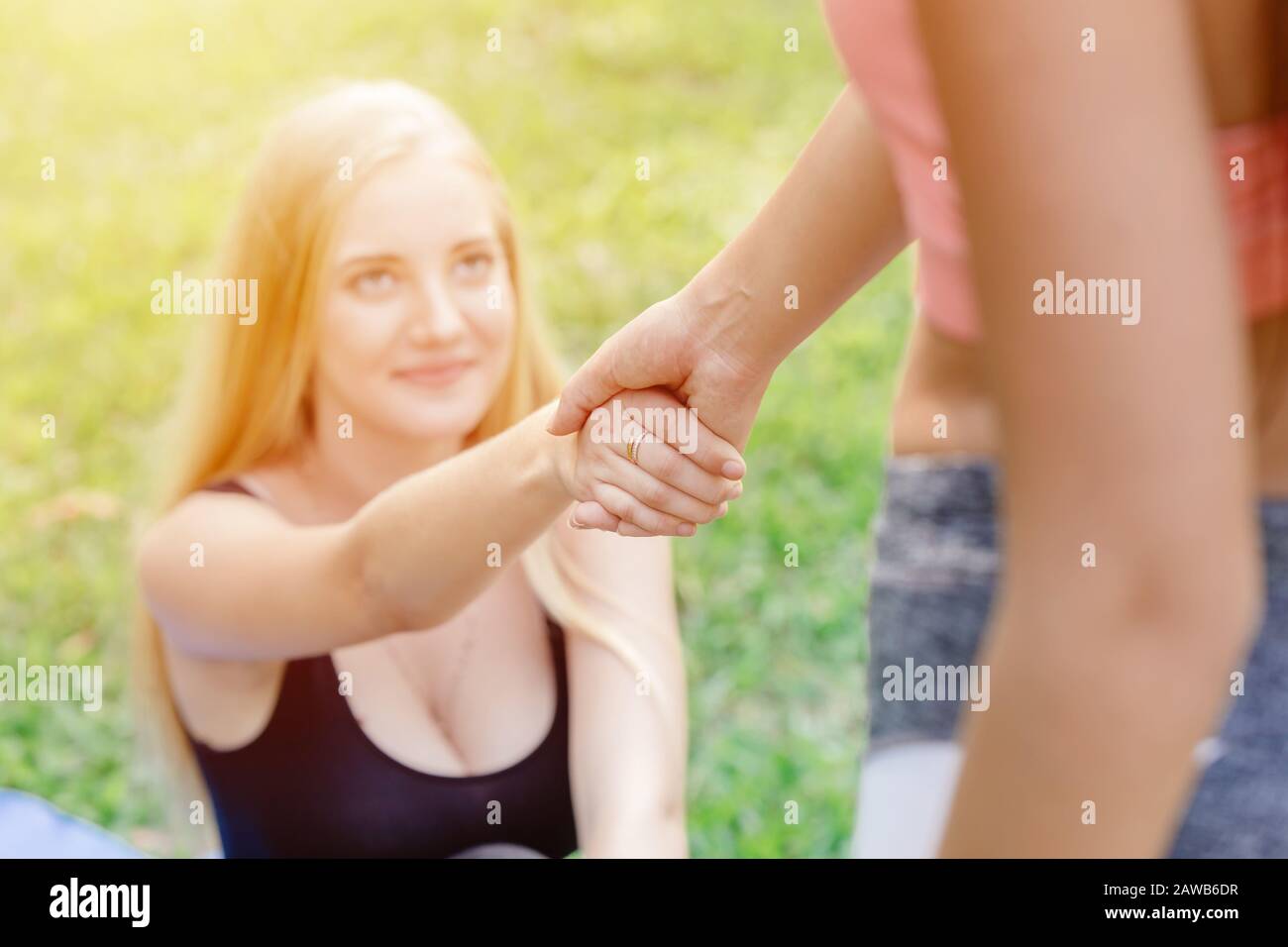 Sport Mädchen Teenager helfen Freund, sich zu kümmern Hand halten ziehen sich gegenseitig, um zu unterstützen und zu trainieren. Stockfoto