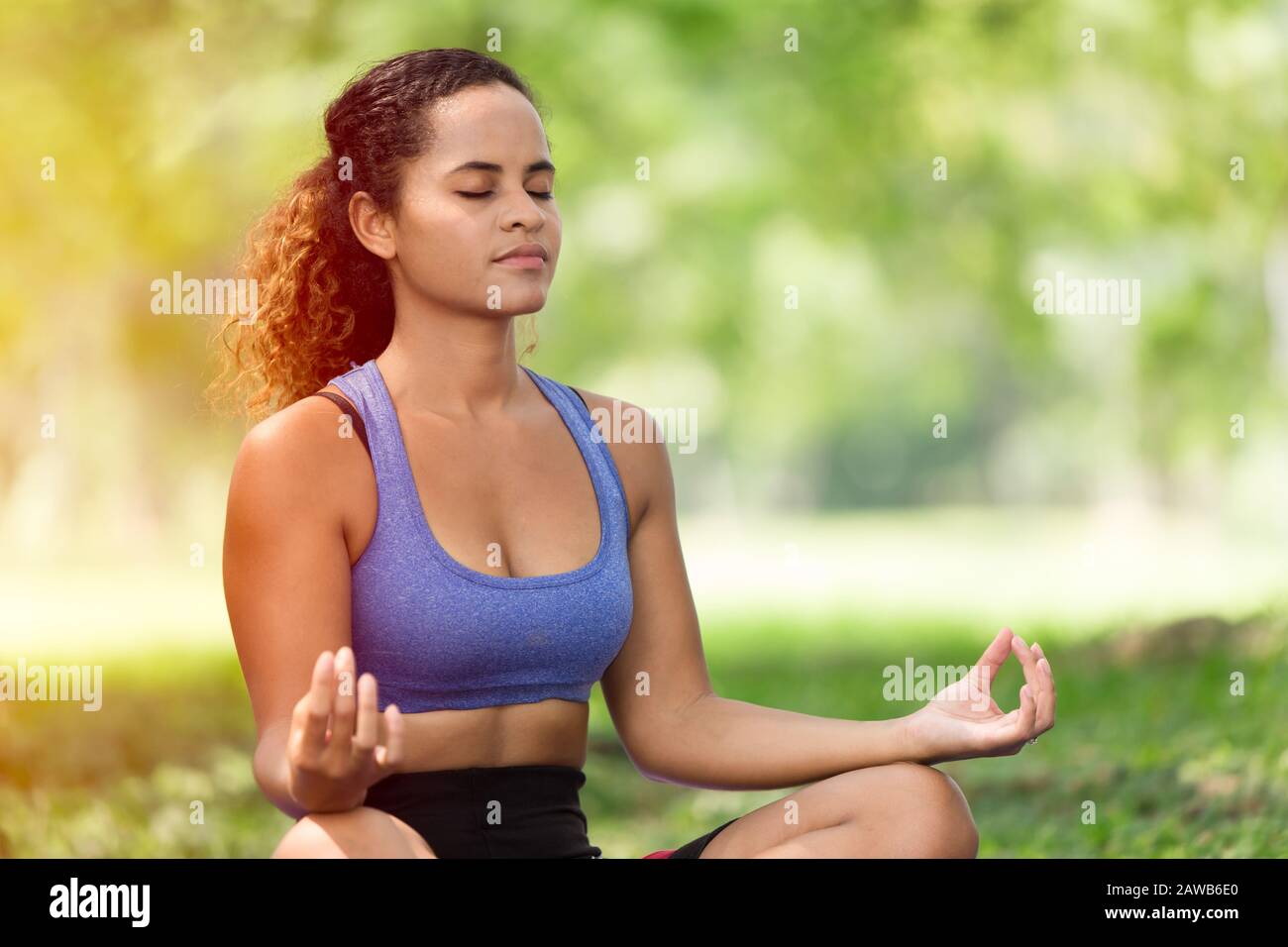 Frauen, die Yoga-Konzentration für die mentale Gesundheitsmeditation im Freien durchführen, Mädchen schwarze kaukasische Rasse Stockfoto