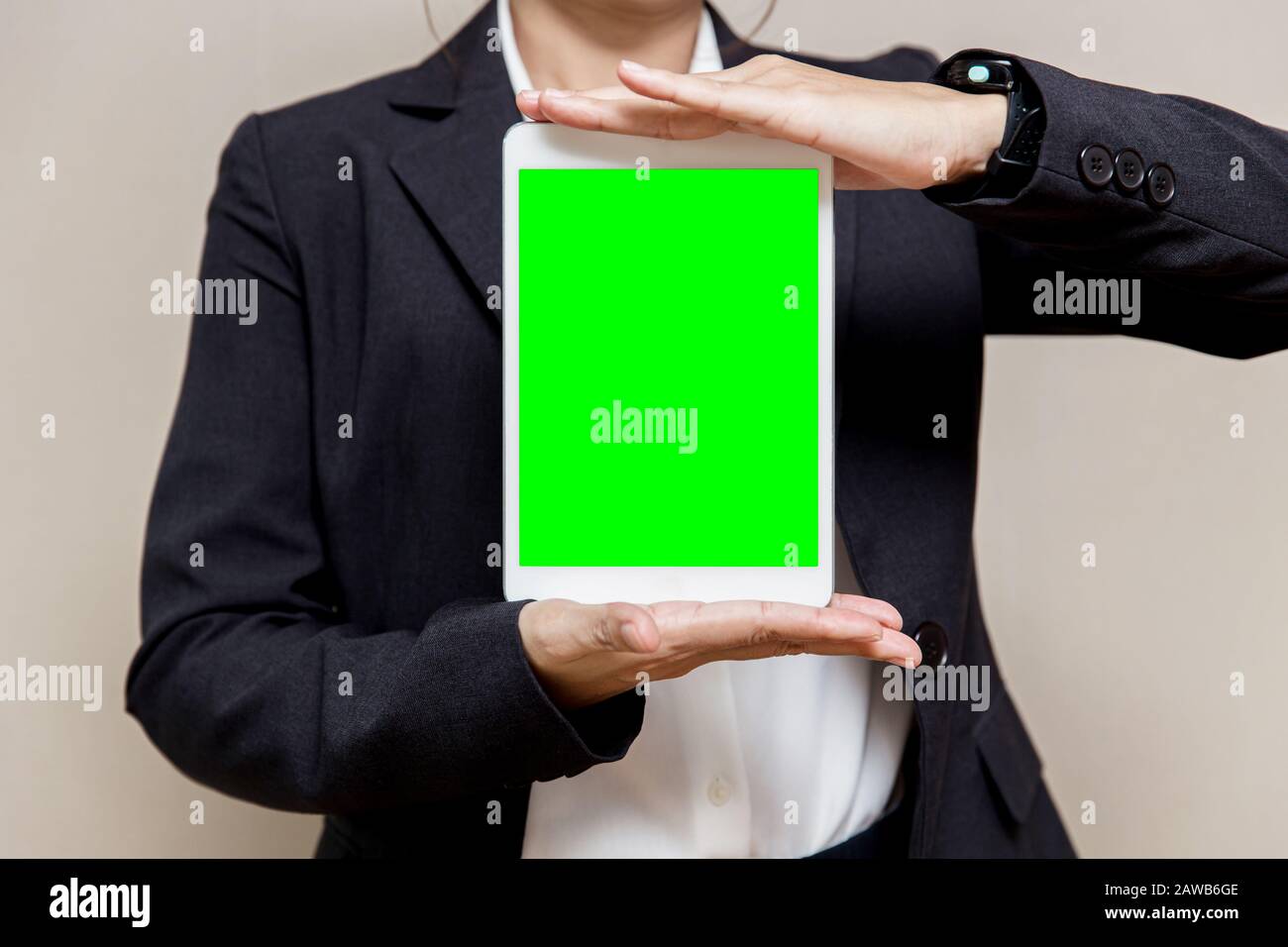 Business Damen, die ein Tablet mit leerem grünen Bildschirmbereich für Text anzeigen. Stockfoto