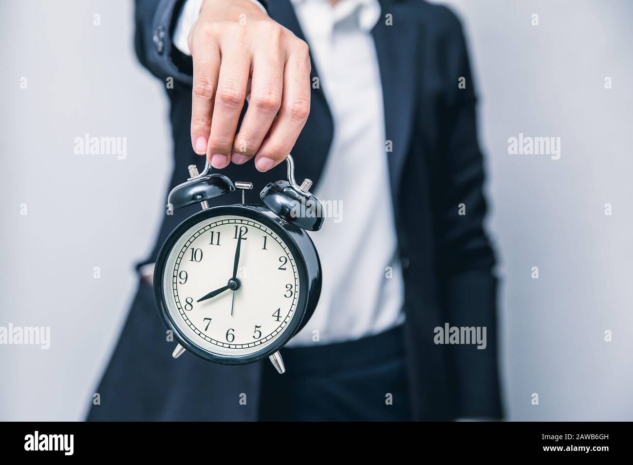 Geschäftsleute mit Uhrzeiten, die für die Warnzeit angezeigt werden, verzögern dringende oder beeilen sich mit dem Arbeitskonzept Stockfoto
