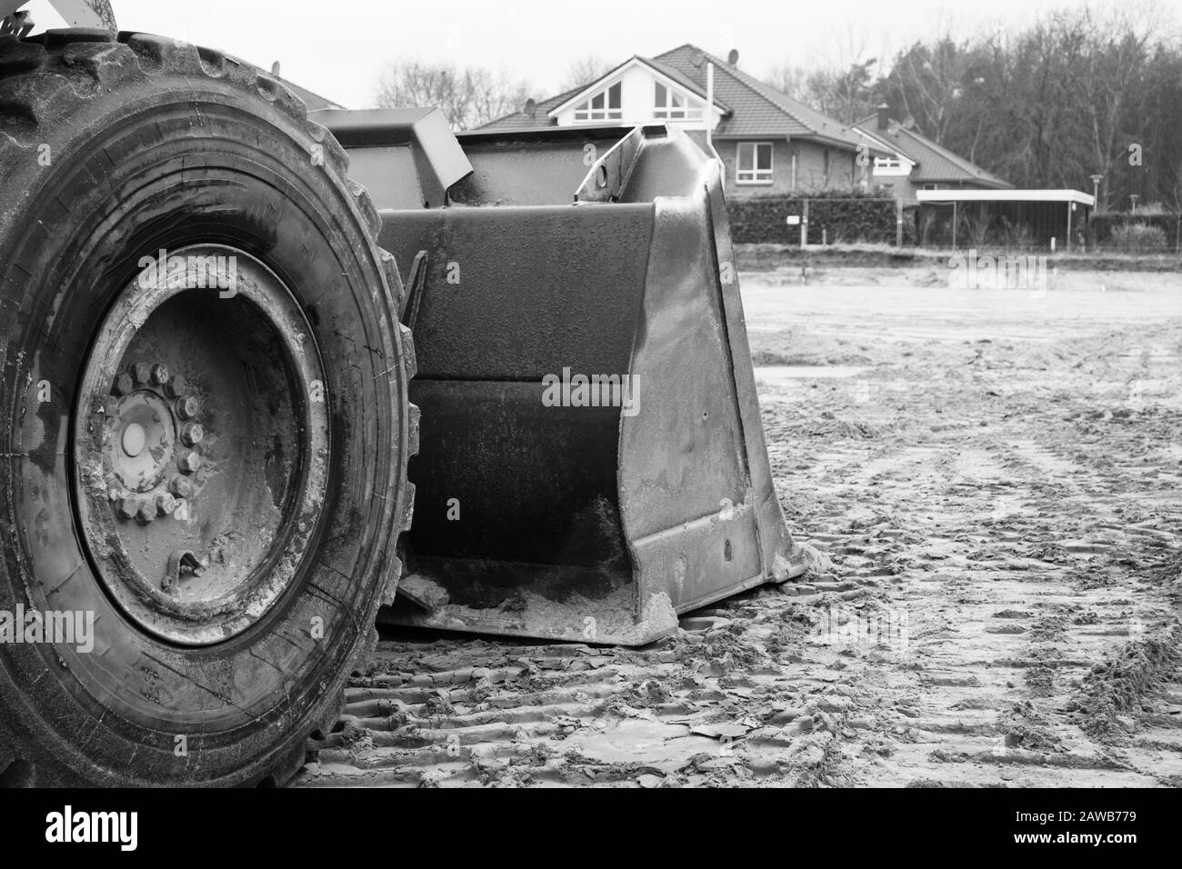 Auf einer Baustelle befindet sich ein orangefarbener Bagger, der den Boden auf Fundamente vorbereitet Stockfoto