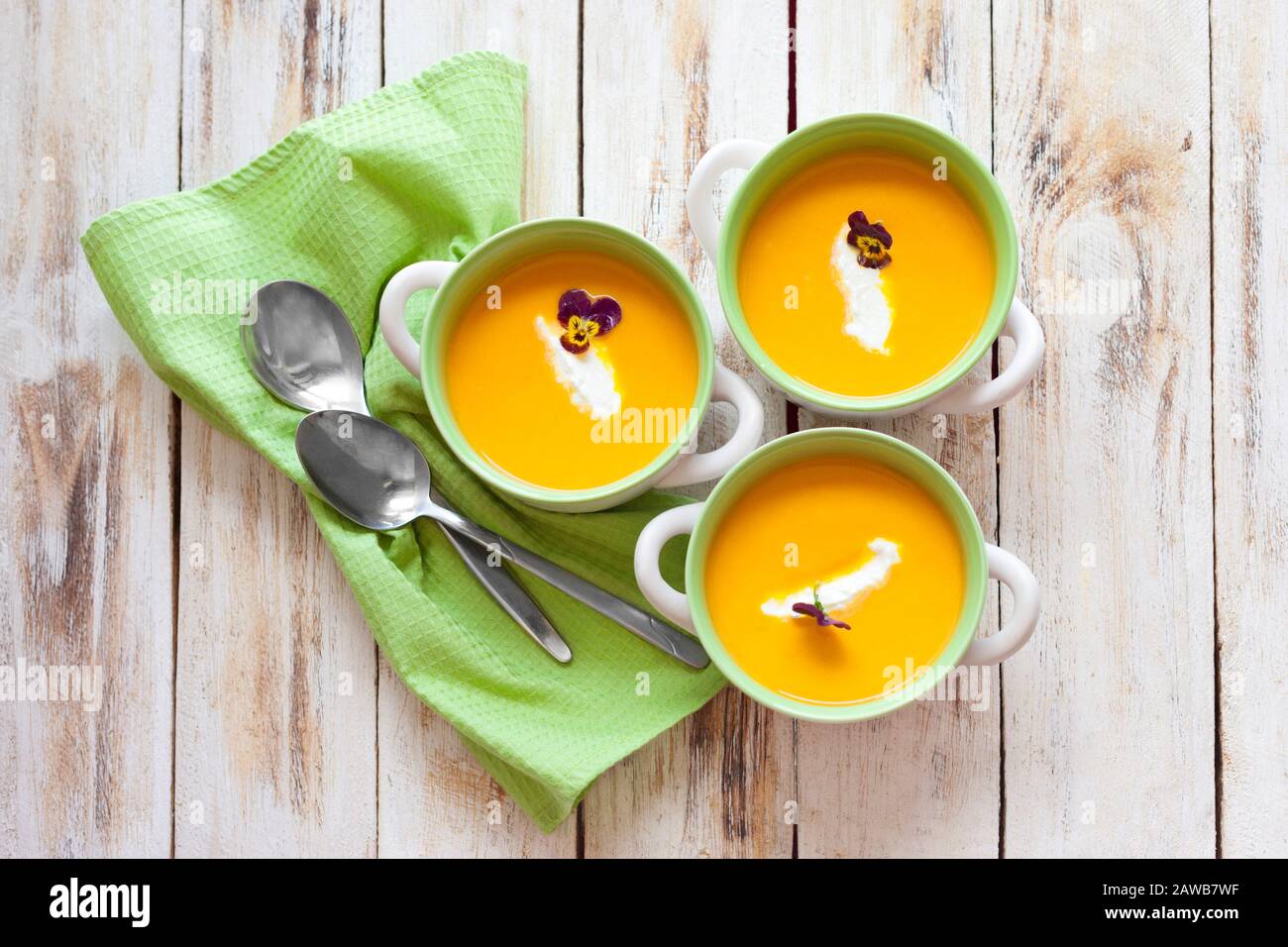 Püree Suppe aus orangefarbenem Kürbis, Süßkartoffeln und Karotten, serviert mit saurer Sahne Stockfoto