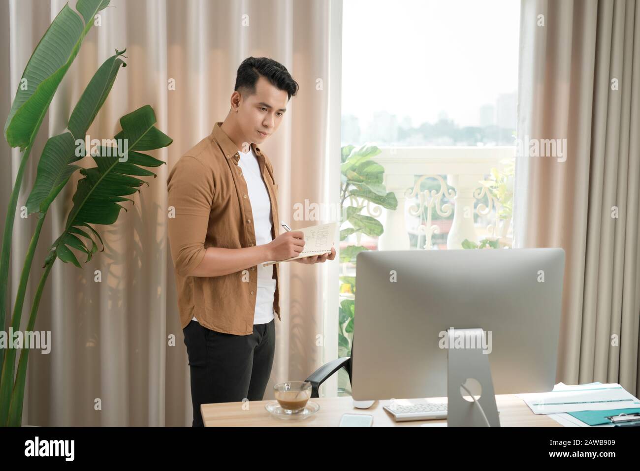 Asiatische Executive 25-35 an der Rezeption ab. Er denkt an ein neues Marketing sorgfältig planen. Stockfoto