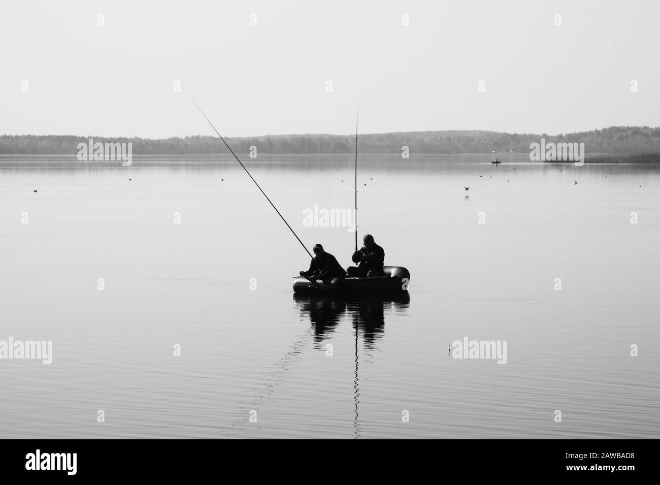 Fischer fangen Fisch. Silhouette von Fischern auf einem Fischerboot. Ruhiger Hintergrund Stockfoto