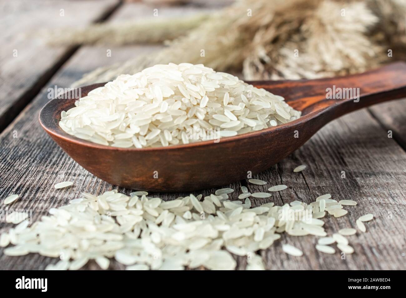 Weißer Reis mit einem Holzlöffel auf einer Stele. Jasminreis zum Kochen. Nahaufnahme. Stockfoto