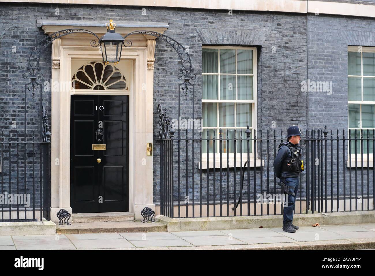 Ein Polizist, der die Einfahrt zur Downing Street Nr. 10 in Westminster, London, Großbritannien bewacht Stockfoto