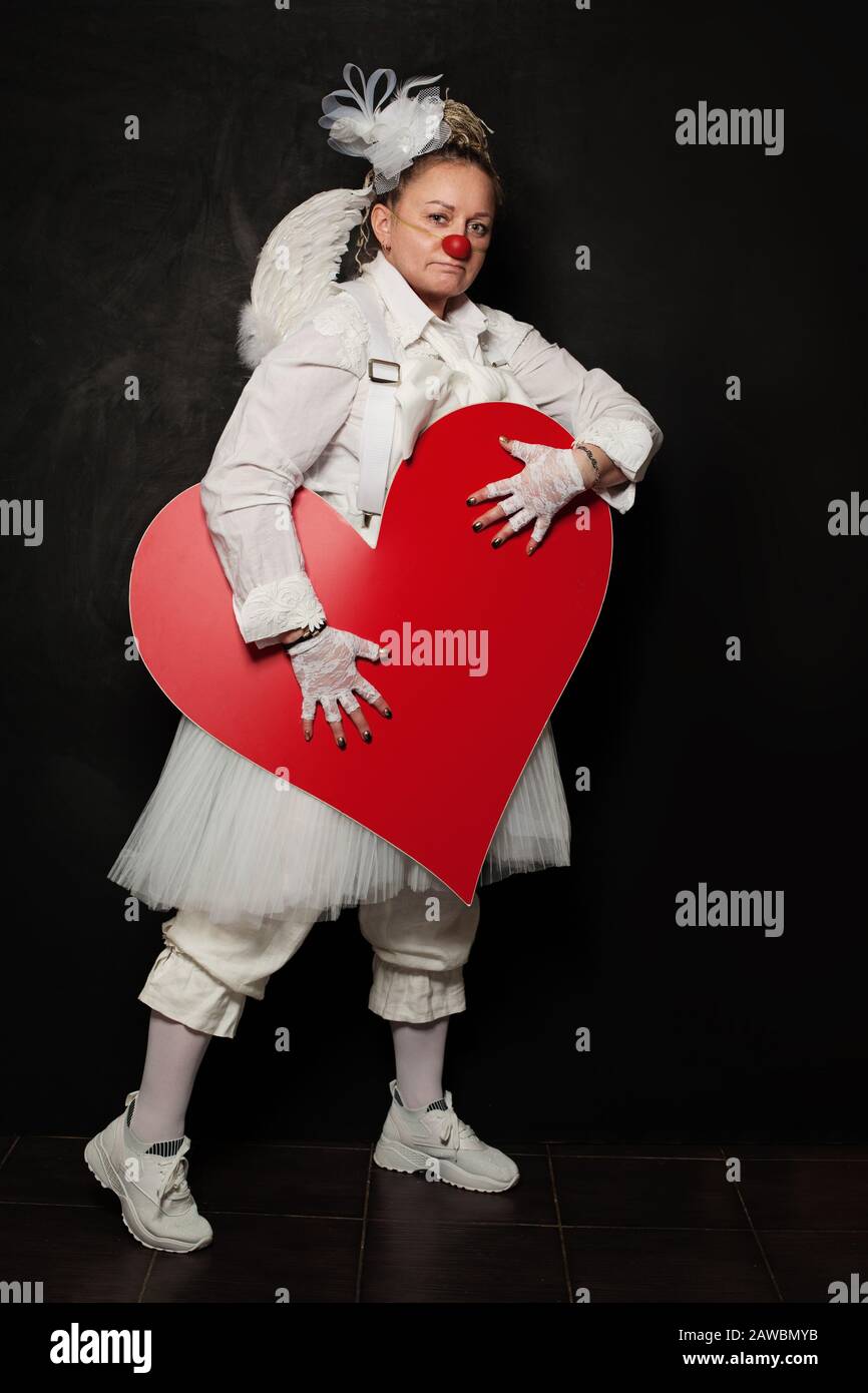 Porträt der Schauspielerin Lady in Clownkostüm mit rotem Herzen bei der Arbeit Stockfoto