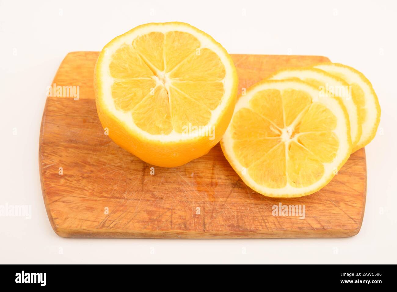 Reife gelbe Zitronenscheiben auf einem Brett auf weißem Hintergrund. Nahaufnahme Stockfoto