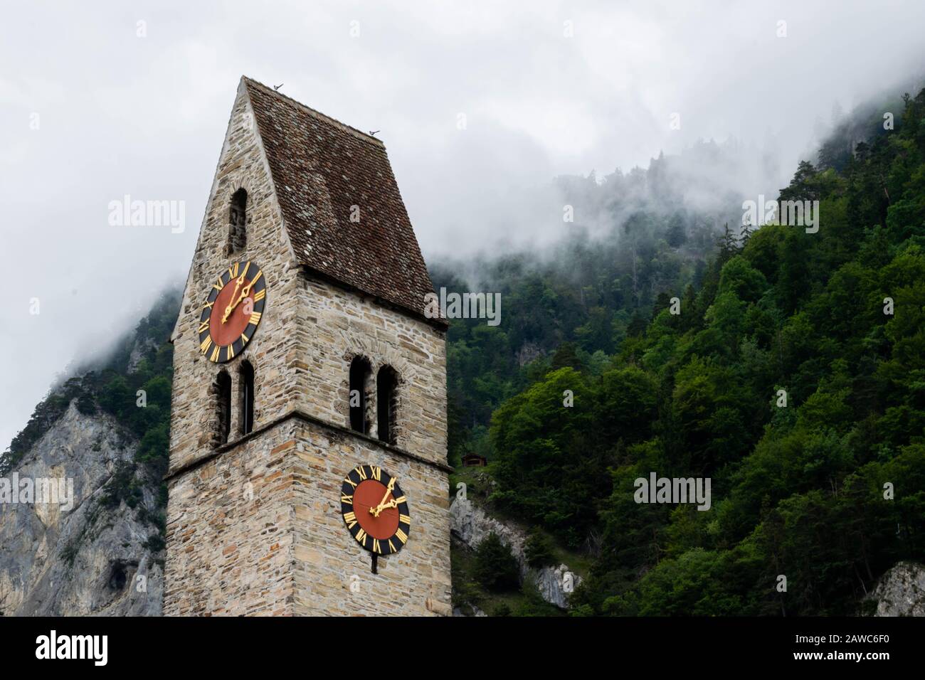 Alte Kirche im deutschen Stil mit roter Uhr in den Bergen, Interlaken Schweiz Stockfoto