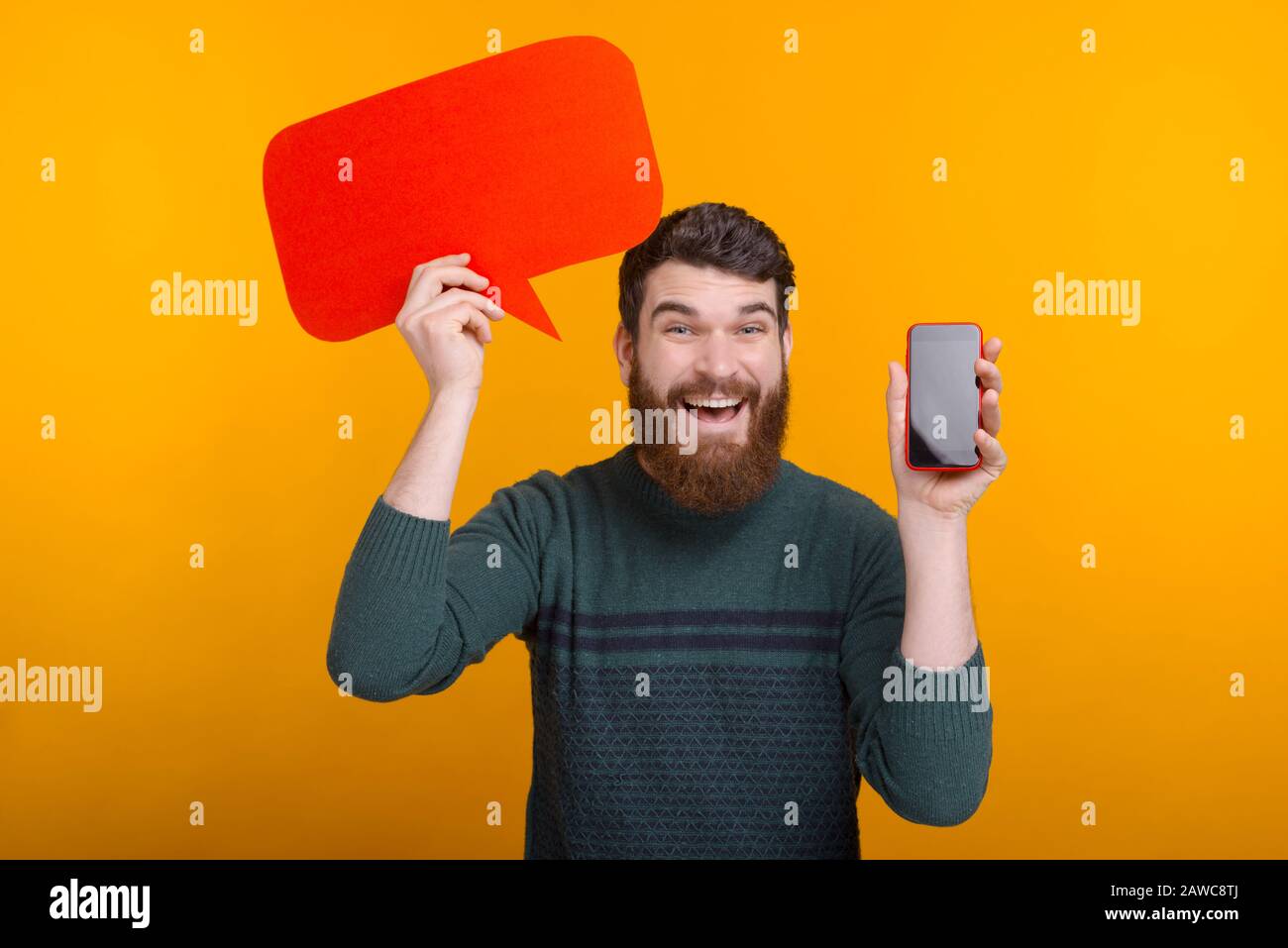Glücklicher, gutaussehender Mann, der rote Sprechblase hält und Smartphone-Bildschirm zeigt, das beste Angebot Stockfoto