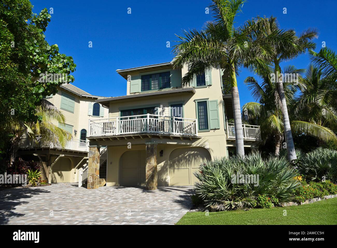 Große Beach House mit Deck, Garagen und eine wunderschöne Landschaft mit Palmen Stockfoto