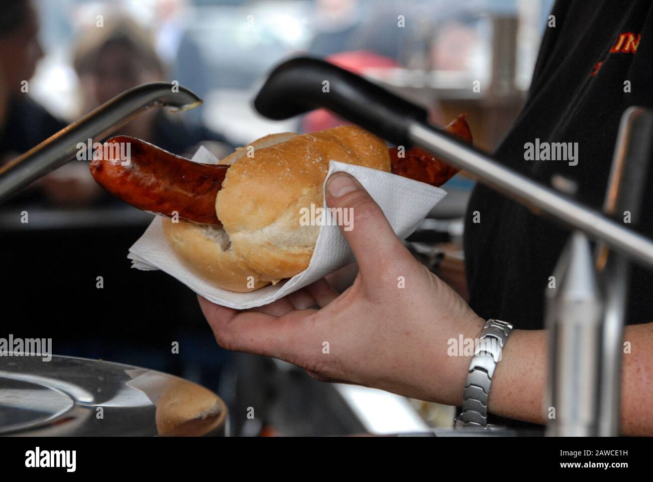 Eine deutsche Wurst wird an einem der ursprünglichen Thüringer Wurststände am Alexanderplatz im Zentrum von Berlin mit Senf bestochen. Die Stockfoto