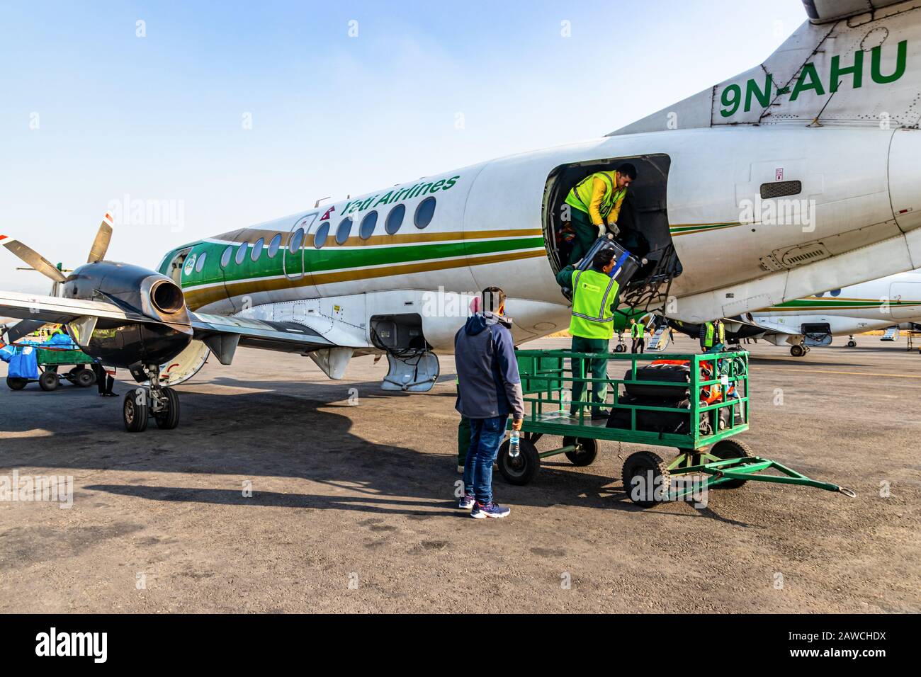 Tribhuvan International Airport, Kathmandu, Nepal, Asien - 16.Dezember 2019: Flughafenmitarbeiter geben Gepäck aus dem Flugzeug von Yeti Airlines frei Stockfoto