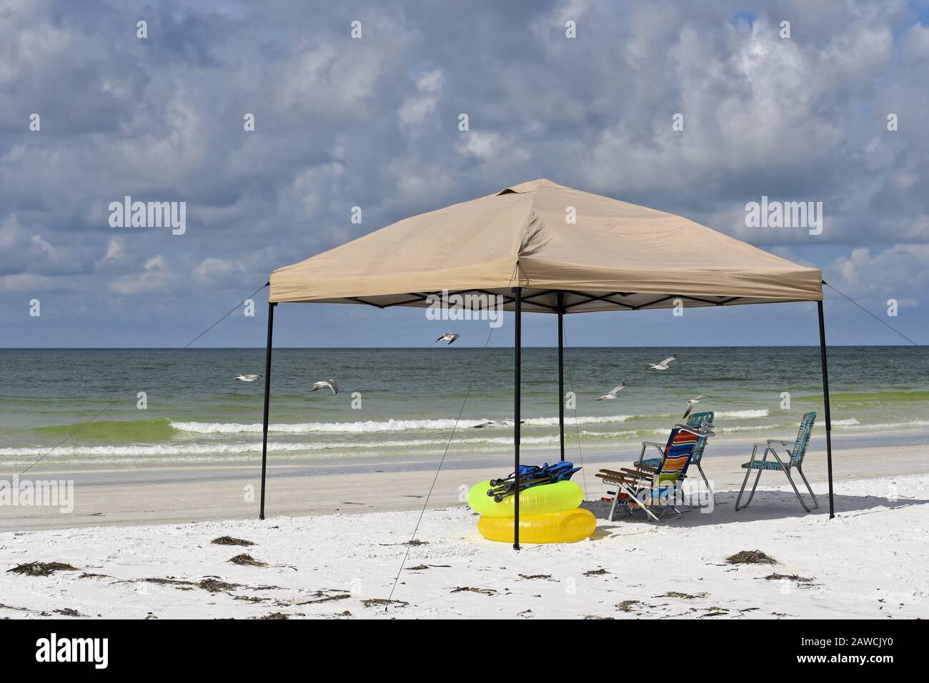 Tragbares Schutzhaus mit Stühlen und Schwimmgeräten am Strand Stockfoto