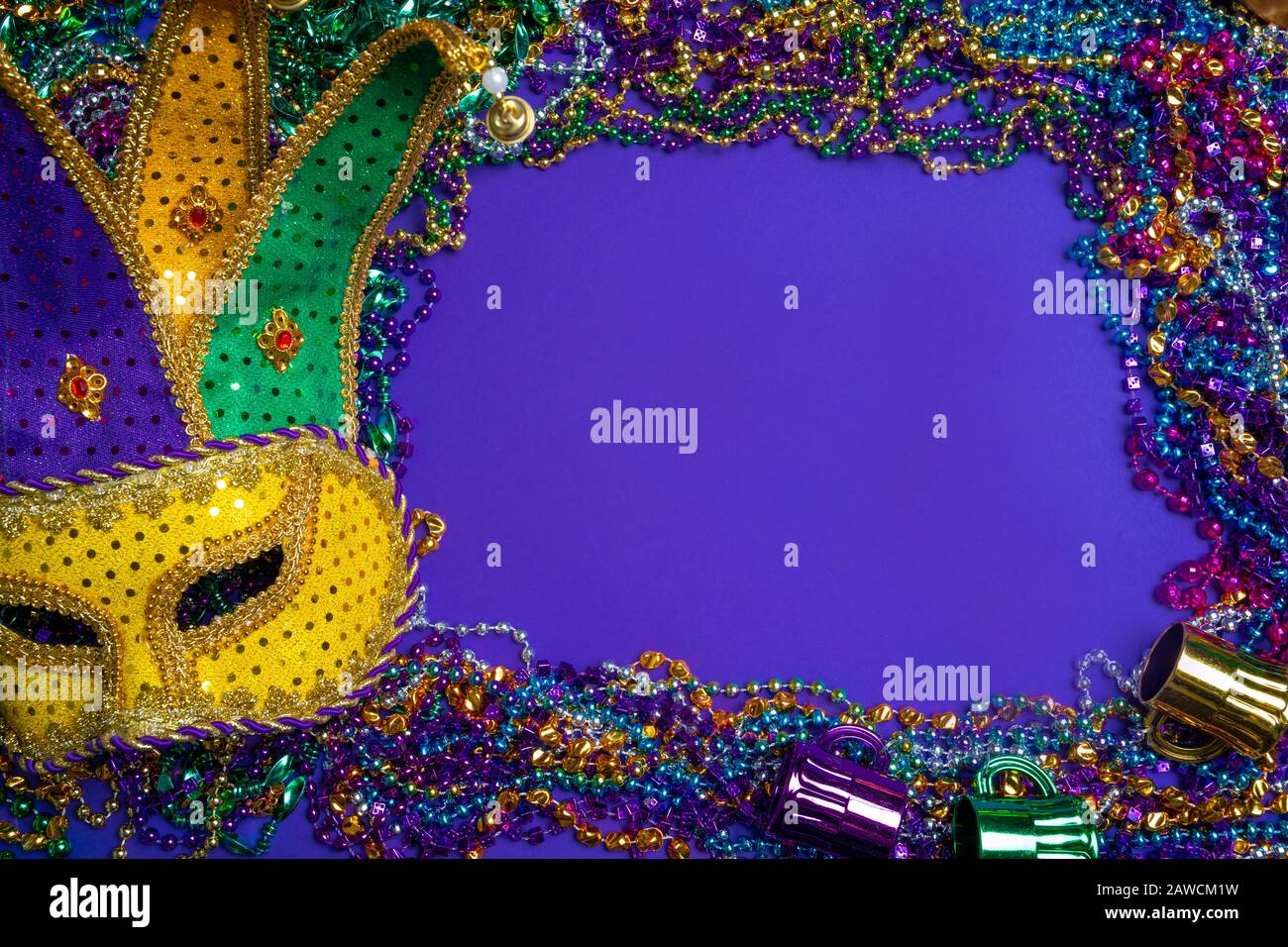 Bunte Mardi Gras Maske auf violettem Hintergrund mit Perlen Stockfoto