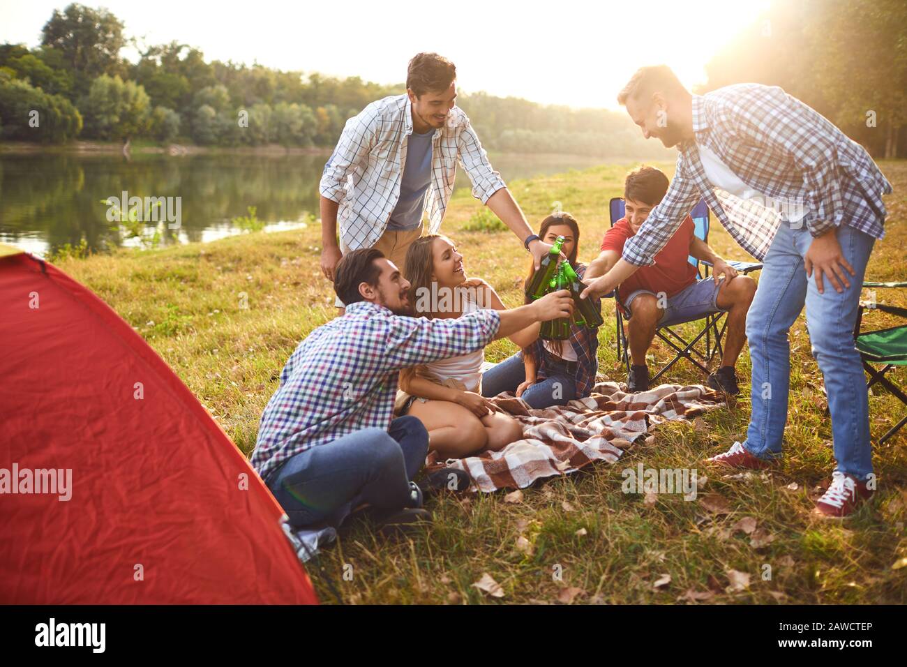 Junge Leute trinken, essen und stinken Gläser bei einem Picknick Stockfoto