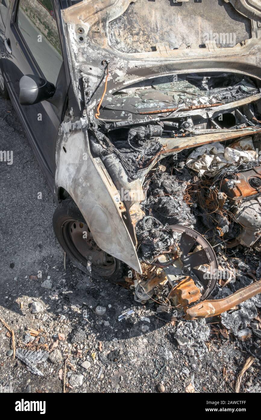 Verbranntes Auto auf einer Straße in der Stadt. Gebuckter Motor. Ansicht von oben. Stockfoto