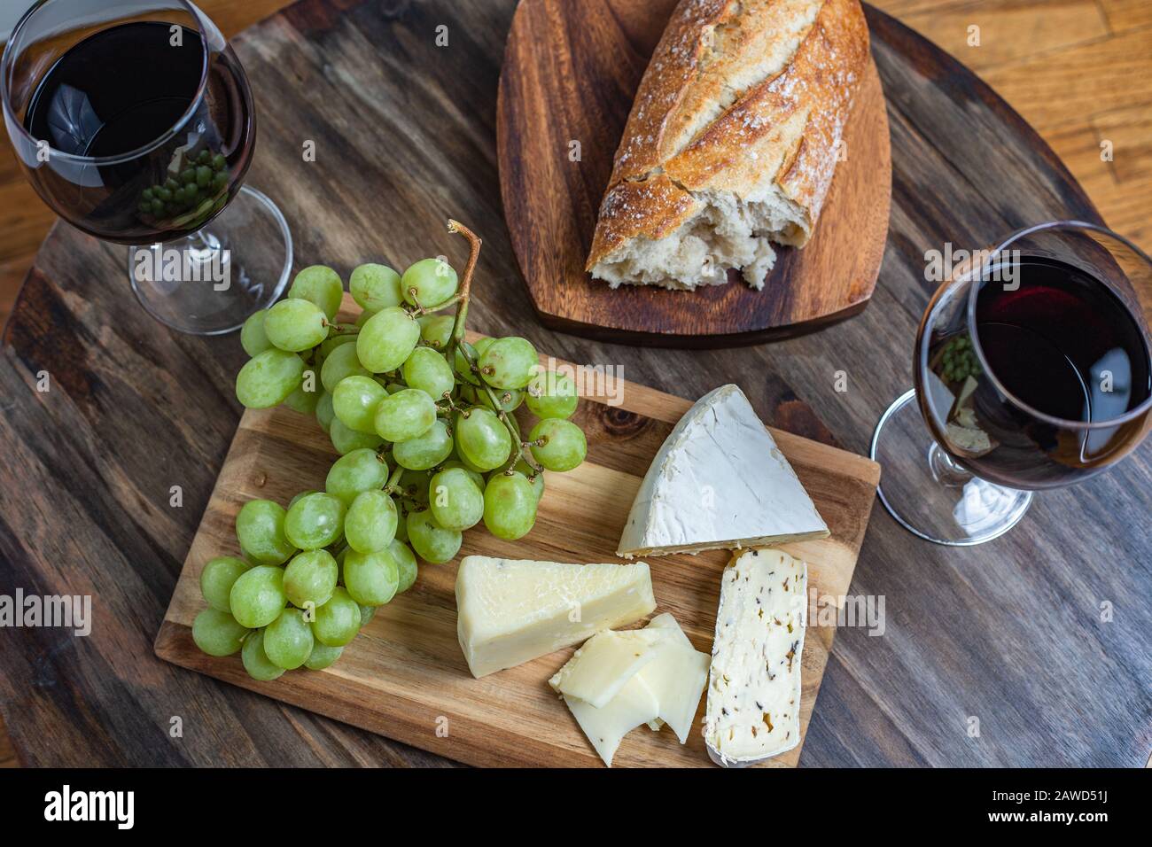 Rotwein- und Käseplatte mit Brot und Trauben, oberster Schuss Stockfoto