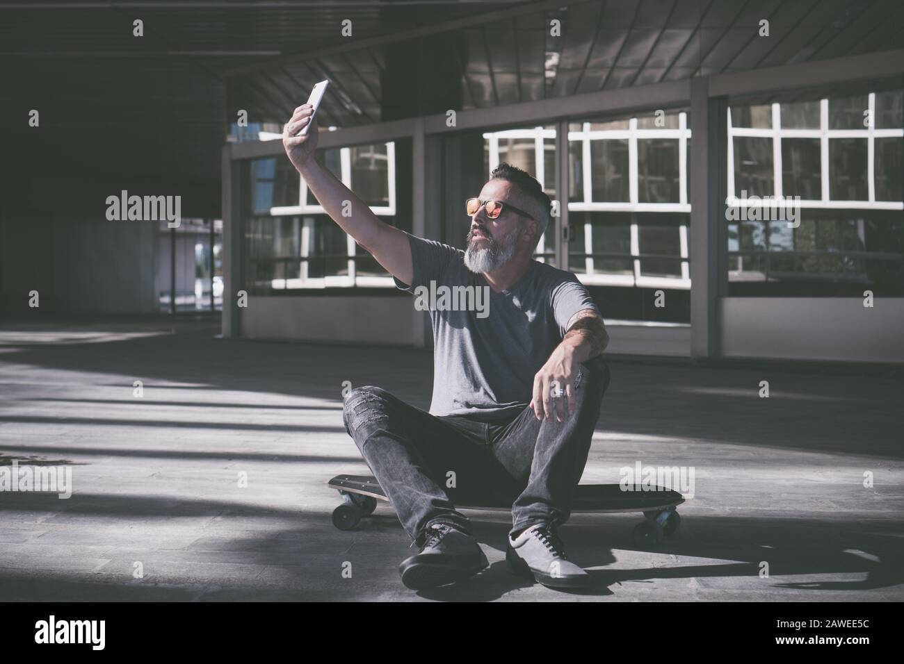 Skater, der ein selfie auf einem Skateboard nimmt Stockfoto