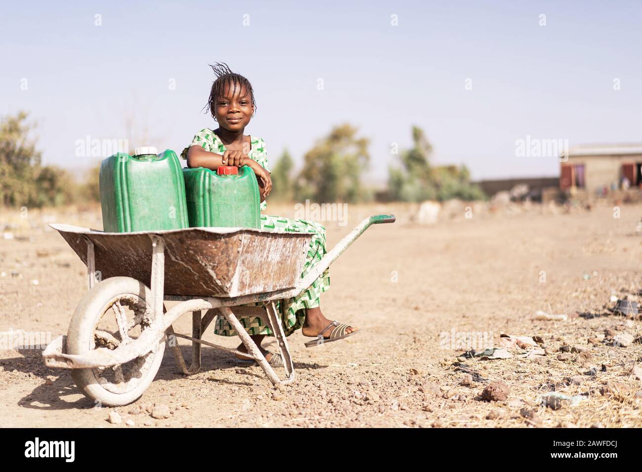 Junge afrikanische Nachkommen, Die Knackiges Wasser in einem Dorf Tragen Stockfoto