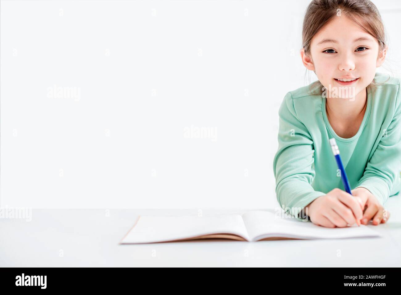 Schöne kleine Mädchen zeichnen und machen Hausaufgaben auf dem Flor Stockfoto