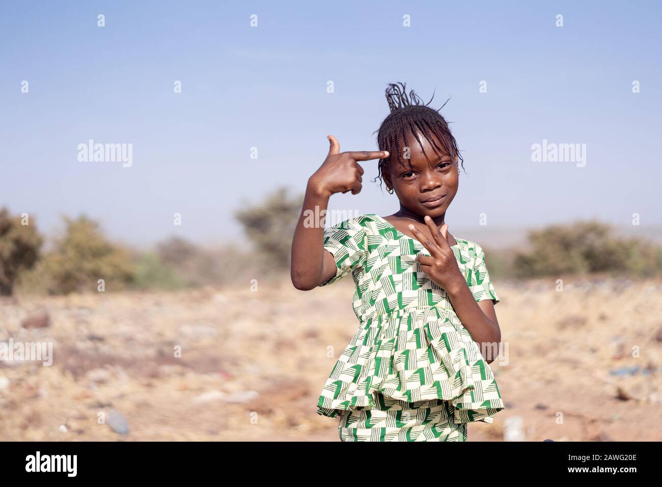 Kleines und süßes afrikanisches Mädchen posiert mit Handgesten für die Kamera Stockfoto