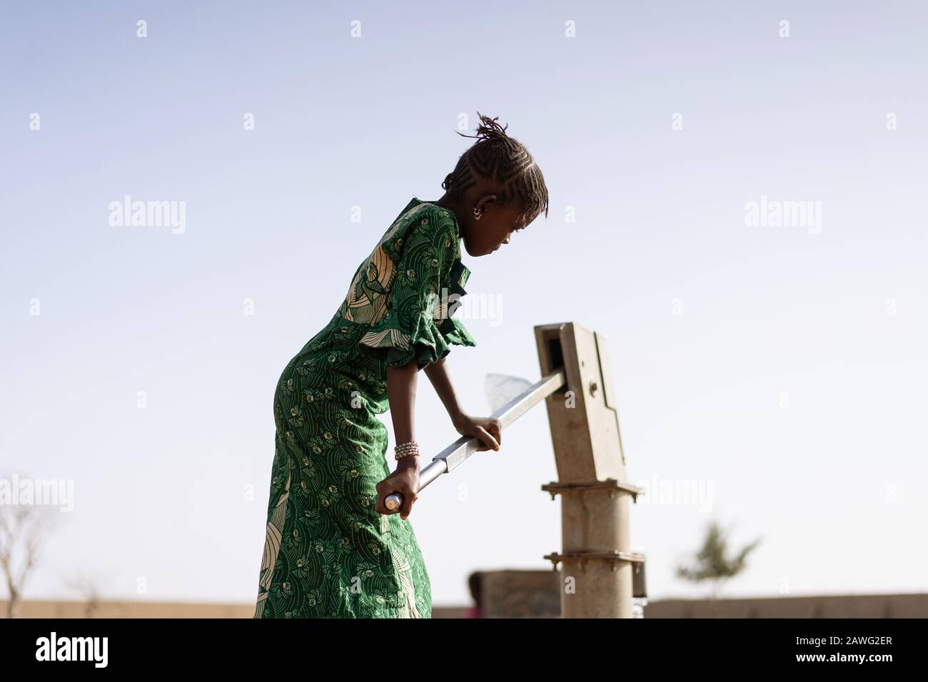 Glückliche westafrikanische Frauen bekommen gesundes Wasser in einem typischen Dorf Stockfoto