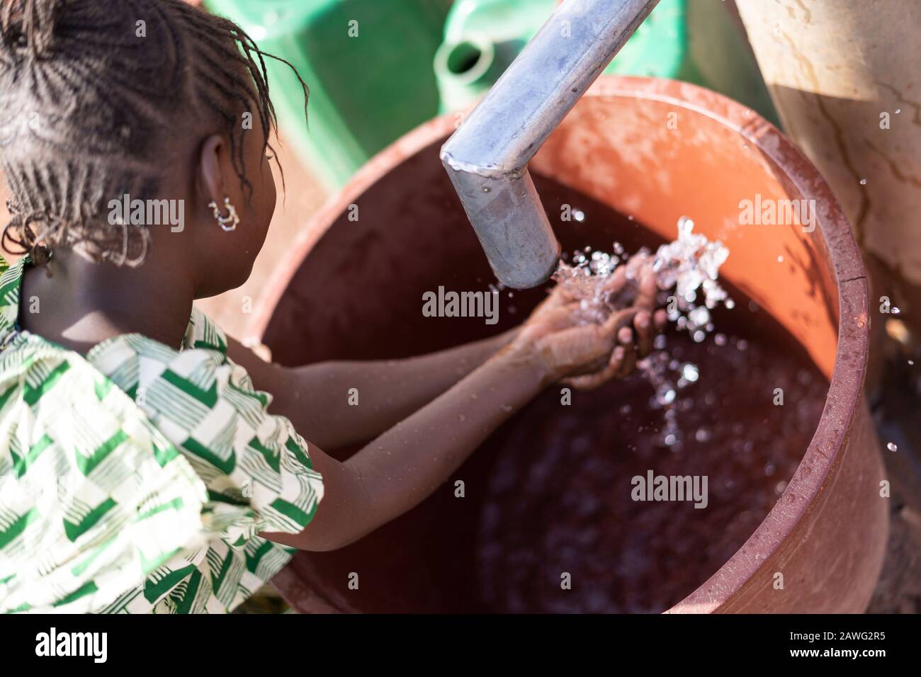 Süßer afrikanischer Ethnicity Nachwuchs Transportiert nährstoffreiches Wasser für ein Konzept der Insuffizienz Stockfoto
