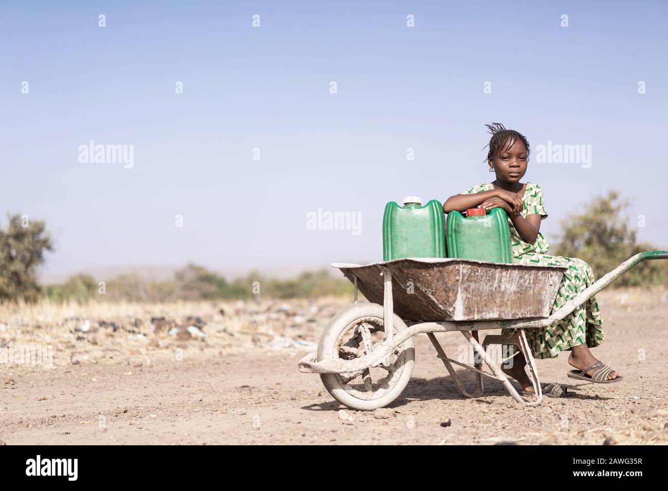 Süße gebürtige Afrikanerinnen, Die in einem Dorf gesundes Wasser Tragen Stockfoto