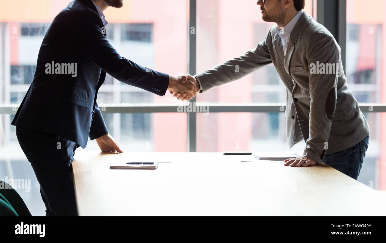 Zwei Geschäftsleute schüttelten die Hände bei der Besprechung, um Einigung zu erzielen Stockfoto