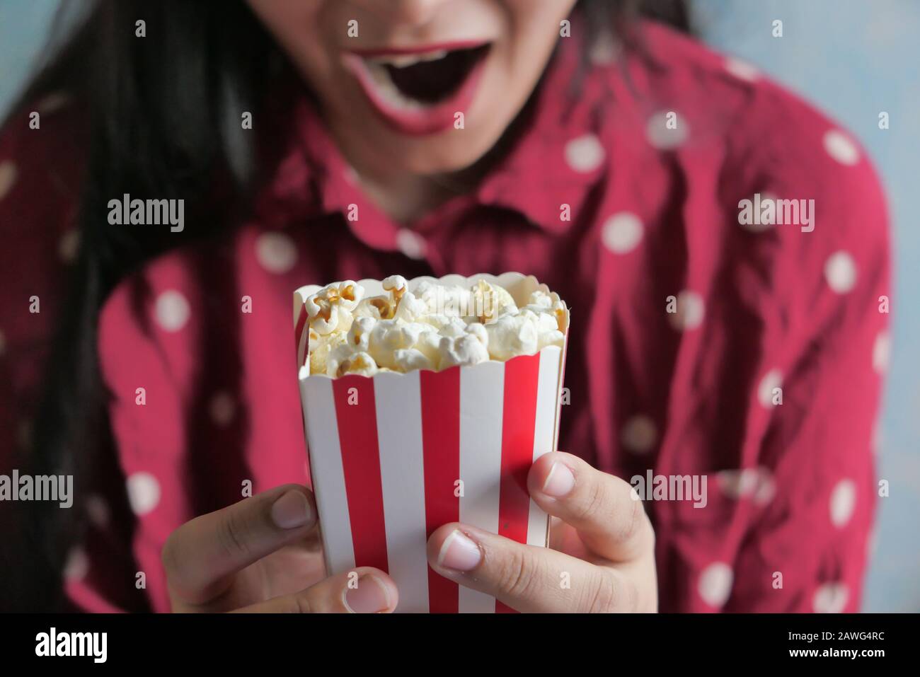 Junge Frauen mit rotem Kleid, die Popcorn essen, Nahaufnahme Stockfoto