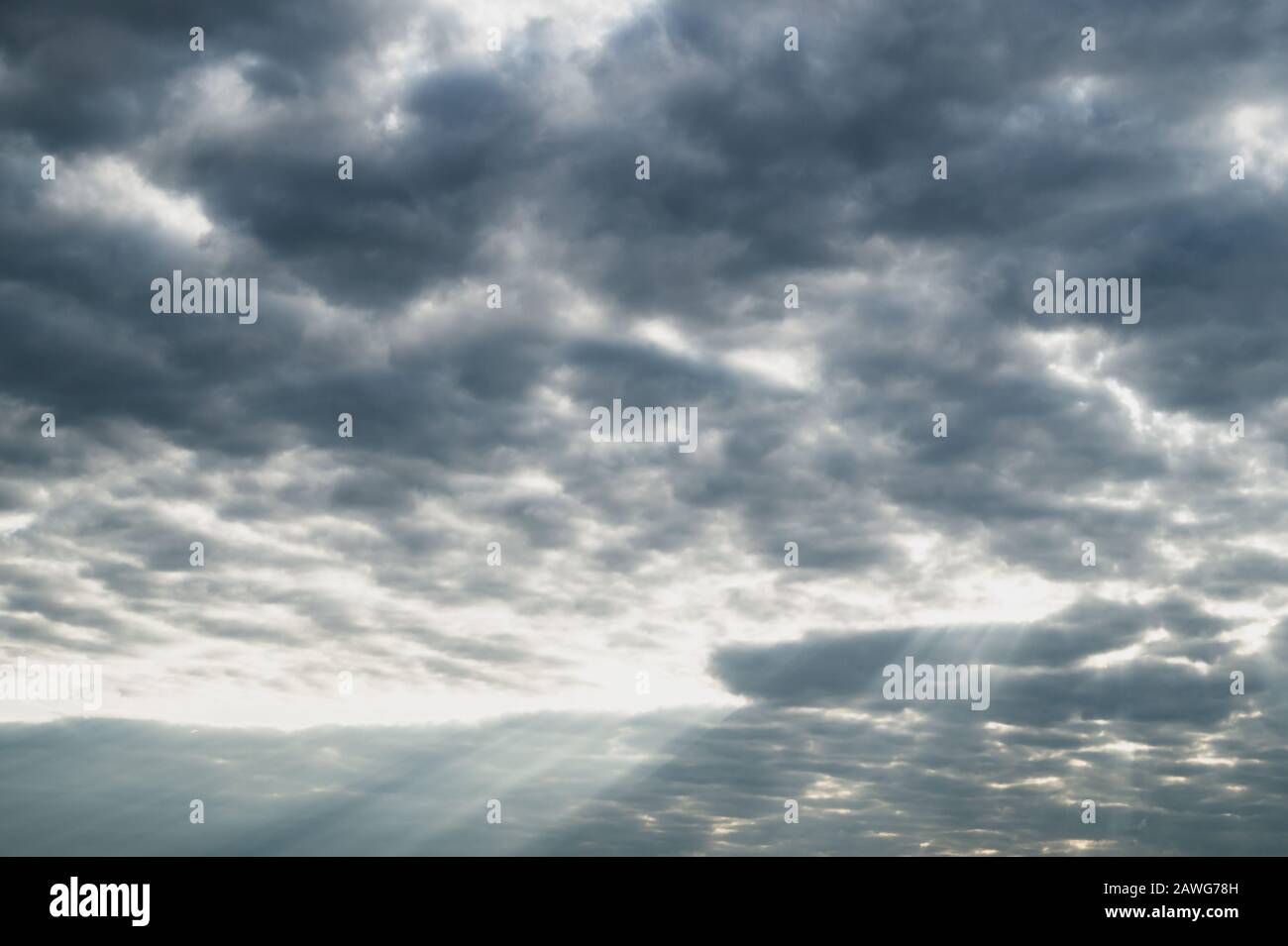 Sonnenlicht scheint durch den bewölkten Himmel, stürmischer Himmel mit Sonnenstrahl, übergiebeltes Wetter Stockfoto