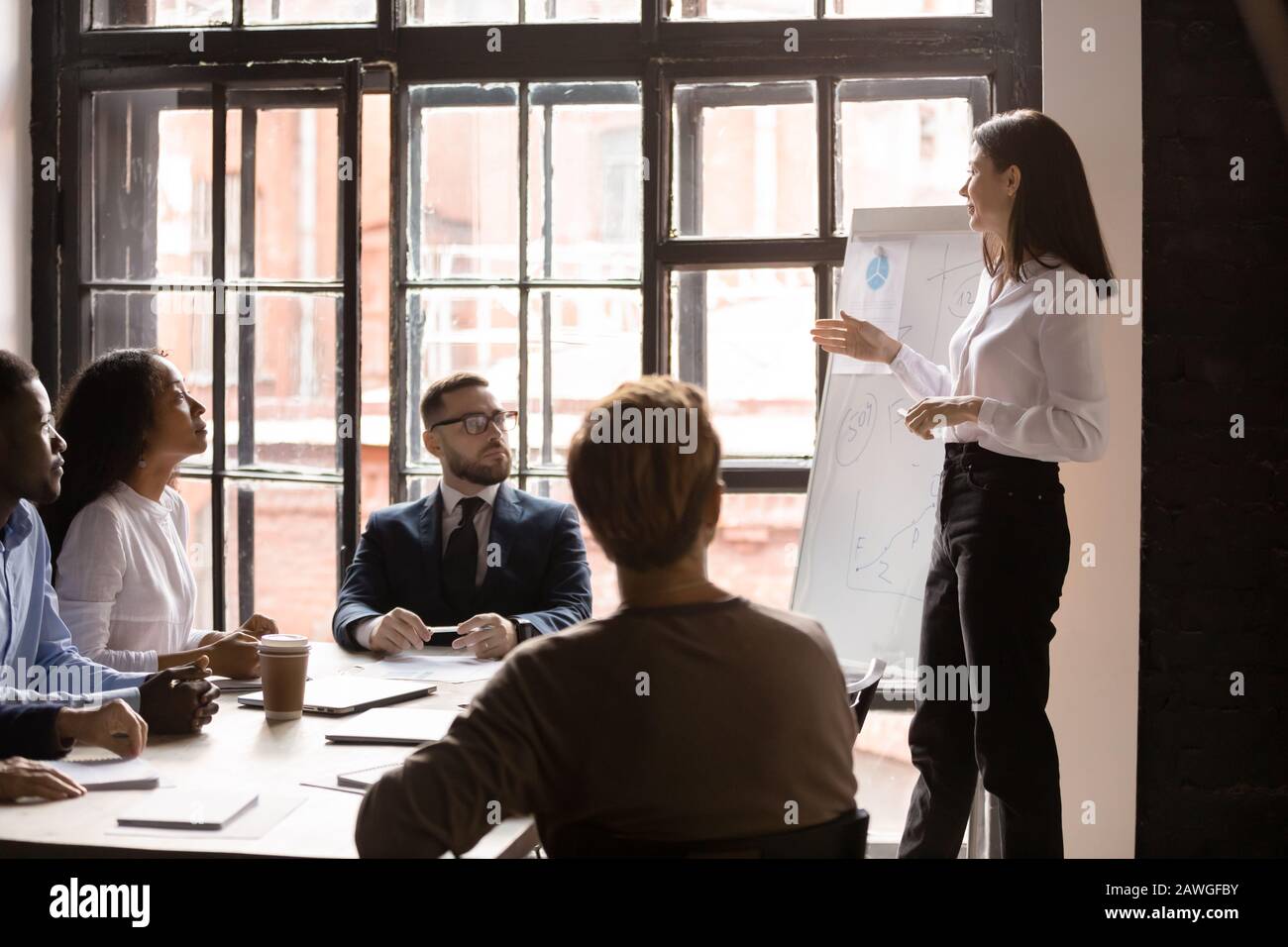 Zuhörer hören weiblichen Business Trainern während der Firmenschulung im Vorstandssaal zu Stockfoto