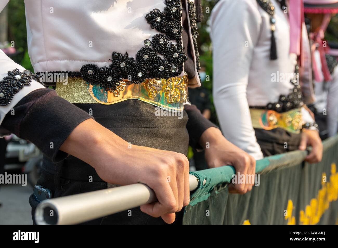 Bild der traditionellen Herrenbekleidung für thailändische Hände, die Bambusstange halten - ausgewählter Fokus Stockfoto