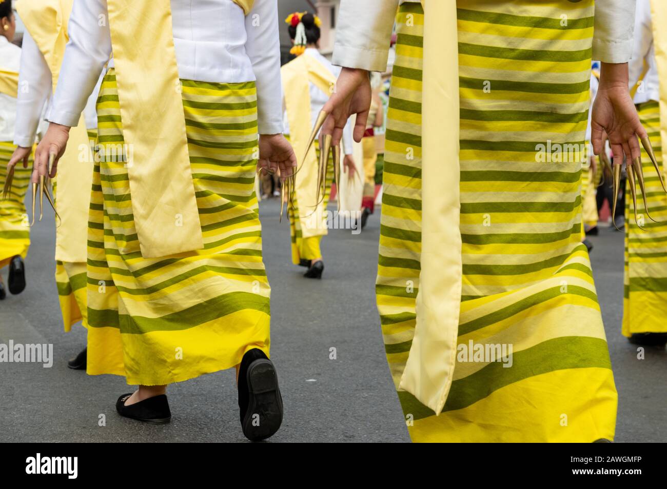 Bild der Frauen mit langen Fingernägeln und traditionellen gelben Gewändern Parade - ausgewählter Fokus Stockfoto