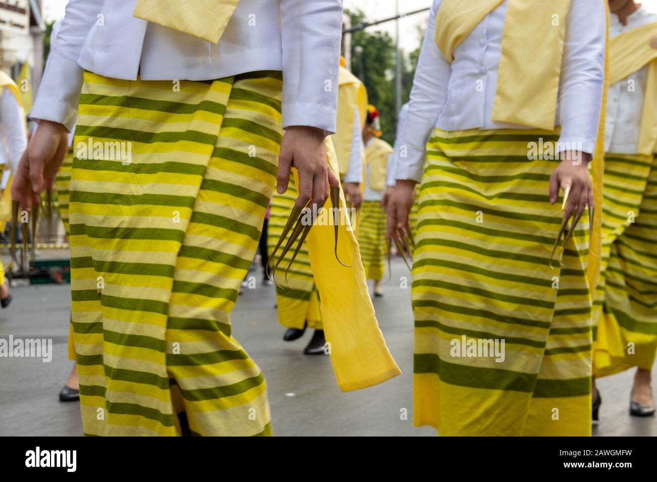 Bild der Frauen mit langen Fingernägeln und traditionellen gelben Gewändern Parade - ausgewählter Fokus Stockfoto